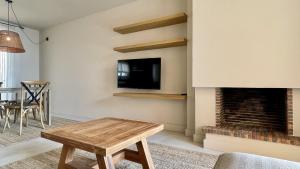 a living room with a tv and a fireplace at Golf Mar II F 2-4 in Pals