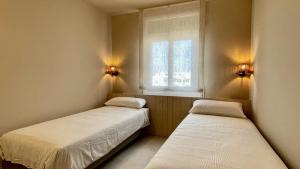 two beds in a small room with a window at Golf Mar II F 2-4 in Pals +23 photos