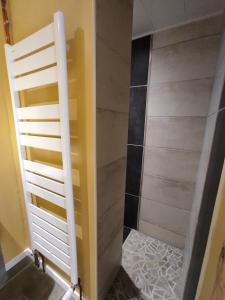 a bathroom with a shower with a white door at Gîte du p'tit randonneur in Verrières-en-Forez