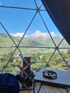 a room with a table and a view of mountains at Elia Glamping in Stepantsminda