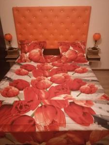 Una cama con flores rojas encima. en Homestay in Tbilisi center GM, en Tiflis