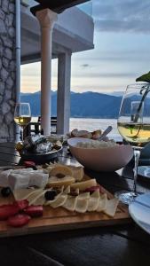 un tavolo con cibo e bicchieri di vino e formaggio di La casa di Sonja a Tivat