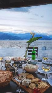 ein Tisch mit Essen und Gläsern Wein darauf in der Unterkunft La casa di Sonja in Tivat