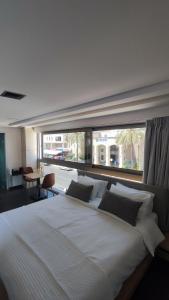 a bedroom with a large white bed with a large window at Summertime Signature Suites in Agia Marina Nea Kydonias +49 photos