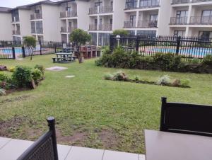 a park in front of a apartment building at Topanga Holiday Apartment in Uvongo Beach