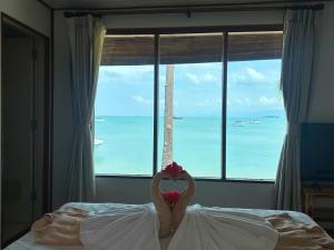 two swans in a bed in front of a window at Bangrak Pier Bungalow in Bang Rak Beach