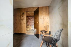 two chairs and a table in a room with wooden walls at Bushi Resort & SPA in Skopje