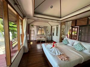 a bedroom with a bed with a doll on it at Bangrak Pier Bungalow in Bangrak Beach