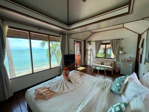 um quarto com uma cama grande e vista para o oceano em Bangrak Pier Bungalow em Bangrak Beach