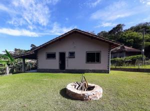 una casa con un patio con un tazón de piedra delante en Casa Rosa Lumiar, Cachoeira Particular e Fazendinha en Lumiar