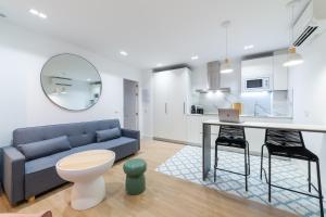 a living room with a couch and a table with a laptop at Exclusivo Loft Catedral in Almería