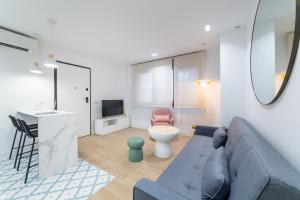 a living room with a blue couch and a tv at Exclusivo Loft Catedral in Almería
