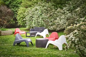 a group of chairs sitting in the grass at Kyriad Direct Le Bourget Gonesse in Gonesse