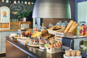 a kitchen with a counter with bread and food on it at Kyriad Direct Le Bourget Gonesse in Gonesse