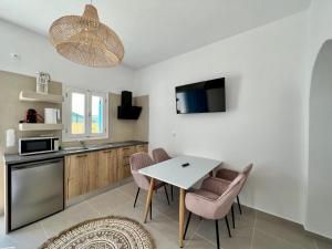 eine Küche mit einem Tisch und Stühlen im Zimmer in der Unterkunft Family Villages Santorini in Vlychada Beach