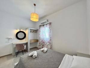 a bedroom with a bed and a desk and a chair at Family Villages Santorini in Vlychada Beach