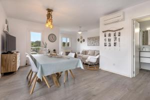 a dining room and living room with a table and chairs at Flat just 280 m from the beach in Can Picafort