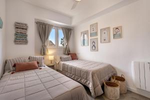 a bedroom with two beds and a window at Flat just 280 m from the beach in Can Picafort