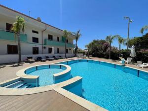 una gran piscina frente a un edificio en Appartamento vista Mare [Il Principe] Free Parking, en Santa Maria del Focallo