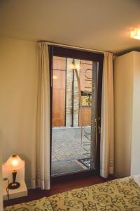 a bedroom with a glass door with a window at Principessa Pio in Ferrara