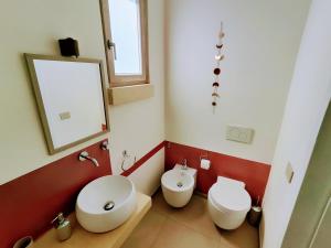 un bagno con un water, un lavandino e uno specchio di Tenuta Sofia a Otranto Altre 128 foto