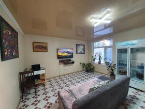 ein Wohnzimmer mit einem Sofa und einem TV in der Unterkunft Hostel Nice in Karakol