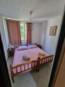 1 dormitorio con 1 cama grande con sábanas rosas en Apartments Residenz Labinci - Einzeln Haus Casa Rustica, en Kaštelir