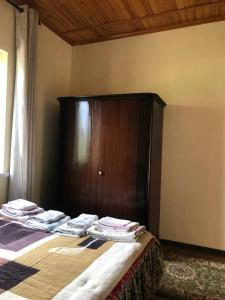 a bed in a room with a wooden cabinet at Legenda Health Resort in Kaji-Say