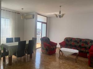 a living room with a table and chairs and a couch at Center of Shkodra Apartment in Shkodër