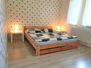 a bedroom with a wooden bed with two tables at Brno apartment in Brno