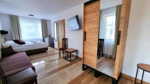 Lubiana Resort في Lubiana: غرفة معيشة مع سرير ومرآة