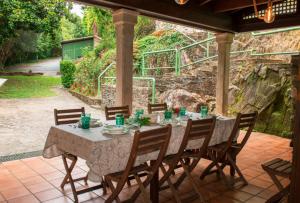 ein Tisch und Stühle auf einer Terrasse in der Unterkunft Molino verde in Coirós