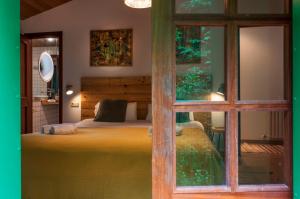 ein Schlafzimmer mit einem Bett und einem großen Fenster in der Unterkunft Molino verde in Coirós