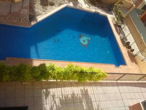 uitzicht over een groot blauw zwembad bij APARTAMENTO LUMINOSO EN URBANIZACIÓN PRIVADA in Granada