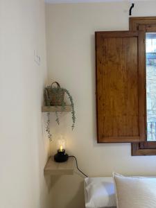 ein Zimmer mit einer Kerze auf einem Regal und einem Fenster in der Unterkunft Apartamento La Fonteta in La Fresneda