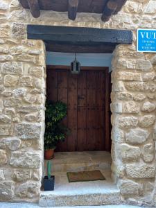 einen Eingang zu einem Steingebäude mit einer Holztür in der Unterkunft Apartamento La Fonteta in La Fresneda
