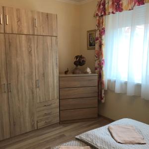 a bedroom with a large wooden cabinet and a bed at Mona Home in Hévíz