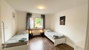 a bedroom with two beds and a window at Cozy Apartment in Remscheid in Radevormwald