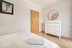 a bedroom with a bed and a mirror and a dresser at Nord Jastarnia bis in Jastarnia +45 photos
