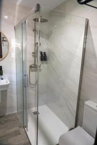 um chuveiro com uma porta de vidro na casa de banho em La Mina de Vega 