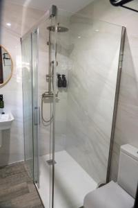 a shower with a glass door in a bathroom at La Mina de Vega in Berbes
