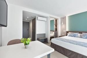 パルマ・デ・マヨルカにあるFeelathome Tortuga de Marのベッド2台とテーブルがあるホテルの部屋