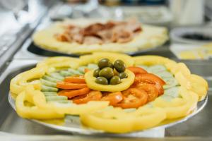 een bord met tomaten en olijven erop bij Pharia Hotel and Apartments - by the beach in Hvar