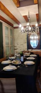 una mesa negra con platos y copas de vino en Viento de Ladera PISCINA NATURAL y JACUZZI EXT en Segovia