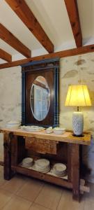 um espelho e uma lâmpada sobre uma mesa com placas em Viento de Ladera PISCINA NATURAL y JACUZZI EXT em Segóvia