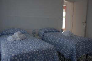 Dos camas en una habitación de hotel con toallas. en Casa Arco, en Torre Suda