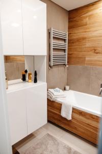 a bathroom with a white sink and a tub at Apartament Staszica Nowa Sól in Nowa Sól