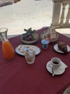 einen Tisch mit Tellern und einer Tasse Kaffee in der Unterkunft Casolare 67 in Noci
