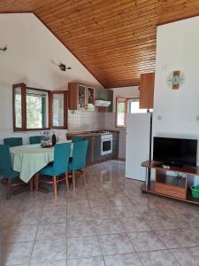eine Küche und ein Esszimmer mit einem Tisch und blauen Stühlen in der Unterkunft Holiday Home Vineyard house in Bol