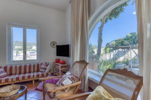 sala de estar con sofá, sillas y ventana grande en Villa Blu La Patronale en Castro di Lecce